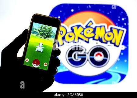 In dieser Fotobilder wird eine Pokémon GO-App auf einem Smartphone mit einem Pokémon GO-Logo im Hintergrund angezeigt. Stockfoto