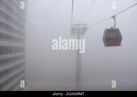 Seilbahnen, die im Nebel in Genting Highlands, Malaysia, fahren Stockfoto