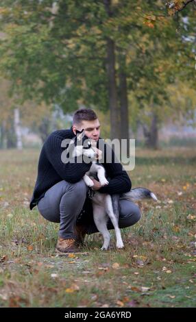 Junger Mann Haustier Besitzer mit Hund im Herbst Park Stockfoto