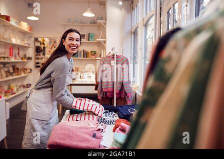 Inhaberin Eines Kleinen Unternehmens Organisiert Die Anzeige Von Aktien Im Fenster Stockfoto