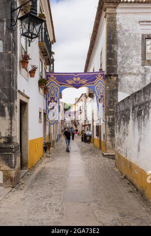 Obidos, Portugal - 30. Juni 2021: Malerische Straße mit touristischen Geschäften in der mittelalterlichen Stadt Obidos Stockfoto