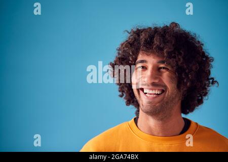 Studio Portrait Of Smiling Young Man Against Blue Background Stockfoto