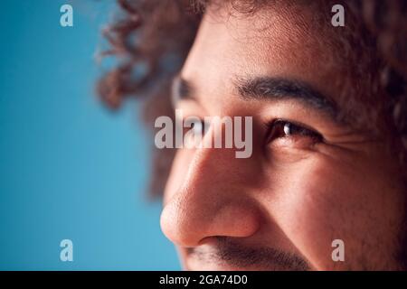 Nahaufnahme Der Augen Von Smiling Young Man Against Blue Background Im Studio Stockfoto