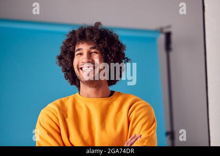 Studio Portrait Of Smiling Young Man Against Blue Background Stockfoto