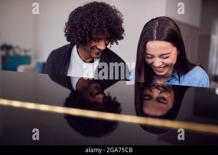 Junge Frau, Die Am Klavier Sitzt Und Unterricht Vom Männlichen Lehrer Hat Stockfoto