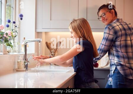 Mutter Mit Tochter, Die Sich Zu Hause Mit Seife Die Hände Wäscht, Um Die Ausbreitung Der Infektion Bei Der Gesundheitspandemie Zu Stoppen Stockfoto