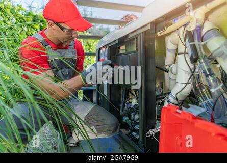 Wohn-Whirlpool-Pumpe Problem lösen durch professionelle kaukasische SPA-Techniker in seinen 40er Jahren. Stockfoto