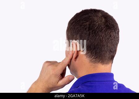 Nahaufnahme Rückansicht eines älteren Mannes, der versucht, das Hörgerät am Ohr aufsetzen, um besser zu arbeiten. Stockfoto
