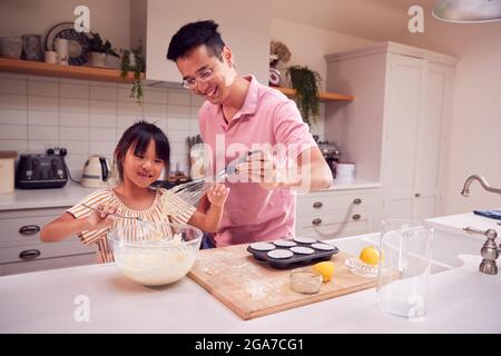 Asiatische Vater Und Tochter Machen Cupcakes In Küche Zu Hause Zusammen Stockfoto