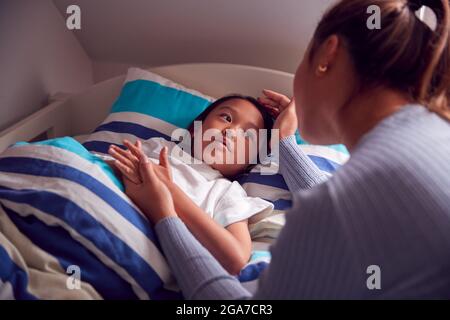 Asiatische Mutter Im Gespräch Mit Tochter Im Oben Etagenbett, Bevor Sie Geht Zu Schlafen Stockfoto