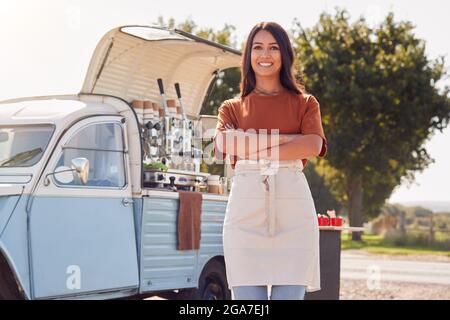 Porträt Einer Frau, Die Neben Van Einen Unabhängigen, Mobilen Coffee Shop Im Freien Führt Stockfoto