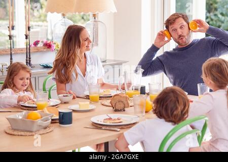 Familie Trägt Pyjama Sitzen Um Tisch Genießen Pancake Frühstück Zusammen Stockfoto