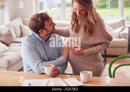 Paar Mit Mann Berühren Schwanger Frauen Magen, Wie Sie Neben Ihm Steht Stockfoto