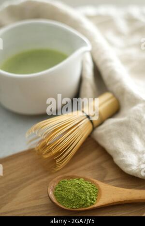 Mischen von grünem japanischem Matcha-Pulver in einem weißen Keramik-Chawan mit braunen Bambusholz-Chasen Stockfoto