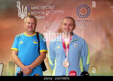 REGION KIEW, UKRAINE - 29. JULI 2021 - Bronzemedaillengewinnerin der Olympischen Spiele 2020 in Tokio im 10m Air Pistol Mixed Team Olei Omelchuk (R) und seinem Trainer Serhii Stockfoto