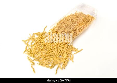 Italienische traditionelle hausgemachte Pasta. Strozzapreti macaroni in transparentem Umschlag auf weißem Hintergrund. Draufsicht mit Kopierbereich. Stockfoto