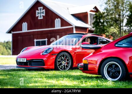 Ein roter Porsche 911 Carrera 4S 2019/2020 (links) und ein 911 Carrera aus dem Jahr 1986. Ein rotes Auto Foto: Pontus Lundahl / TT / Code 10050 Stockfoto