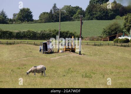 Das Western Power Distribution Team installiert einen neuen Transformer im Inland an einem neuen Mast, der von der neuen Erdverkabelung Cotswolds UK versorgt wird Stockfoto