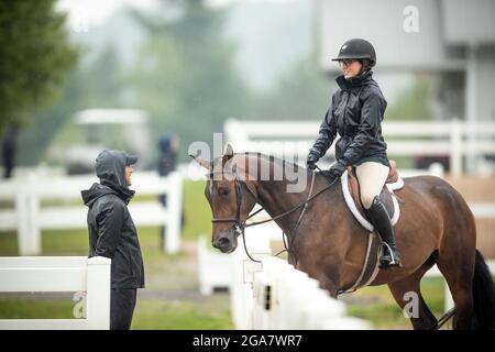 Palgrave, Kanada - 29. Juli 2021. Die kanadische Amateurfahrerin Ellah Dubeau-Kielty, rechts, teilt einen unbeschwerten Moment mit Trainer Mark Hayes auf der Caledon Summer Phase One, Gold Circuit Horse Show im Caledon Equestrian Park. Kredit: Mark Spowart/Alamy Live Nachrichten Stockfoto