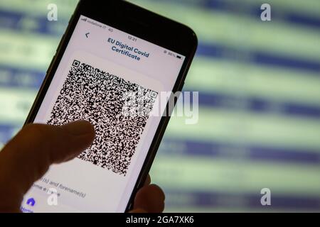 Rom, Italien. Juli 2021. Rom, Italien, Donnerstag, 29. Juli 2021. EU Covid Digital Certificate Green Pass auf Handy vor einem unbestimmten Zugfahrplan in Rom gehalten Stockfoto