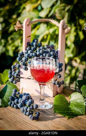 Blaue Trauben und Traubensaft in einem Glas Stockfoto