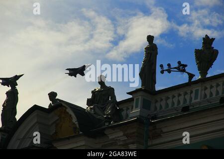 Ein Link von Militärflugzeugen fliegt über die Eremitage und hinterlässt einen umgekehrten Weg Stockfoto