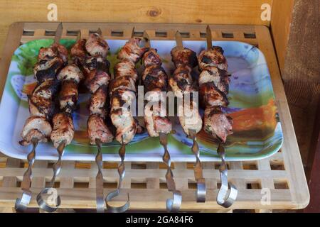 shish Kebab auf Spieße ist blau auf dem Abstand und Holztisch Stockfoto
