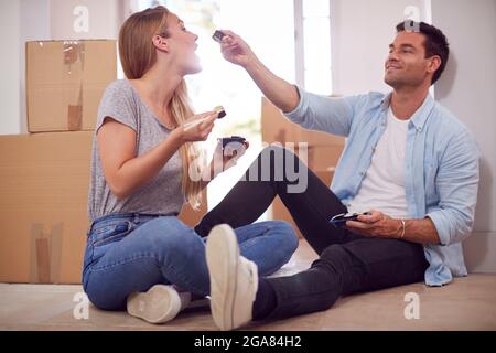 Pärchen Feiern Mit Takeaway-Sushi-Essen Auf Dem Boden Des Neuen Heims Am Umzugsfeiertag Stockfoto