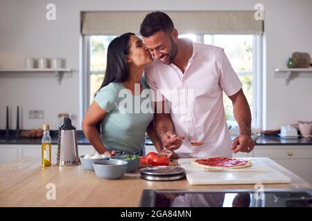 Liebevolles Paar In Der Küche Zu Hause Gemeinsam Hausgemachte Pizzas Zubereiten Stockfoto
