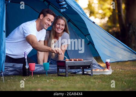 Paar Im Zelt Camping Sitzen Am Grill Und Grillen Würstchen Stockfoto