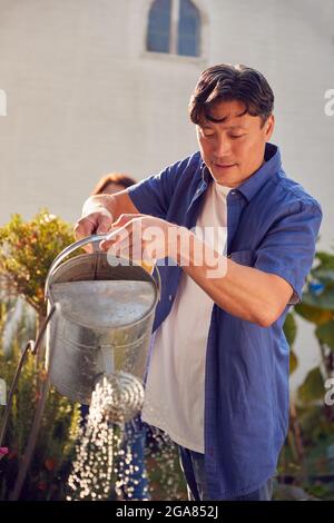 Reifes Asiatisches Paar Bei Der Arbeit Bewässerung Und Pflege Von Pflanzen Im Garten Zu Hause Stockfoto