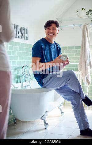 Reifes Asiatisches Paar Trägt Schlafanzug Sitzen Im Badezimmer Genießen Morgen Heiße Getränke Zusammen Stockfoto