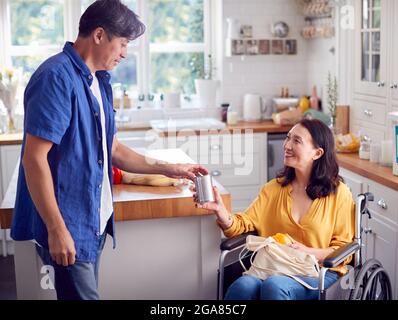 Reif Asiatische Paar Mit Frau Im Rollstuhl Auspacken Einkaufen In Küche Zu Hause Zusammen Stockfoto