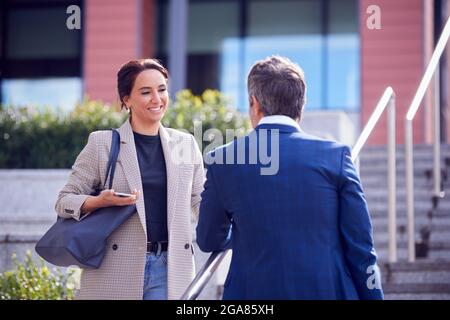Geschäftsmann Und Geschäftsfrau Treffen Sich Im Freien Auf Stufen Stehen Und Reden Stockfoto