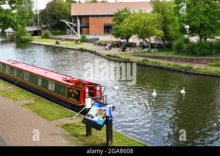 Newbury, Bekshire, England - Juni 2021: Noticeboard für Besucher mit einem Schmalboot, das auf dem Kennet- und Avon-Kanal im Zentrum von Newbury festgemacht ist. Stockfoto