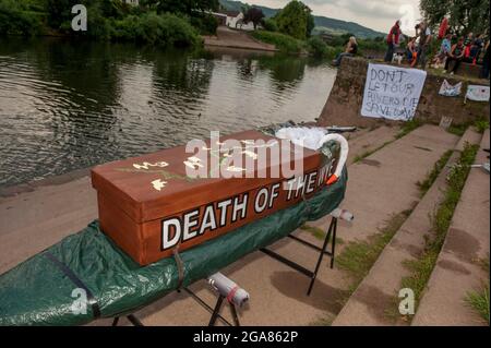 Die Spezialistin für Wildschwimmen und Autorin Angela Jones alias „The Wild Woman of the Wye“ führt ein 1-km-Bad im Monmouth-Abschnitt des Wye-Flusses, um auf den katastrophalen ökologischen Zustand des Flusses Wye und seine anhaltende Verschlechterung aufmerksam zu machen. Ein Nachbau-Sarg auf einem Paddelbrett wurde in den Fluss gesenkt und von Angela geschleppt, um den Tod des Wye darzustellen. Ihr Schwimmen ist Teil der #SaveTheWye, einer Dachkampagne zur Unterstützung und zum Aufbau eines Netzwerks von Organisationen und Einzelpersonen, die sich für den Schutz und die Wiederherstellung der Gesundheit des Flusses Wye und seiner Nebenflüsse einsetzen, sowohl für die Tierwelt als auch für die Menschen Stockfoto