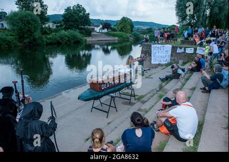 Die Spezialistin für Wildschwimmen und Autorin Angela Jones alias „The Wild Woman of the Wye“ führt ein 1-km-Bad im Monmouth-Abschnitt des Wye-Flusses, um auf den katastrophalen ökologischen Zustand des Flusses Wye und seine anhaltende Verschlechterung aufmerksam zu machen. Ein Nachbau-Sarg auf einem Paddelbrett wurde in den Fluss gesenkt und von Angela geschleppt, um den Tod des Wye darzustellen. Ihr Schwimmen ist Teil der #SaveTheWye, einer Dachkampagne zur Unterstützung und zum Aufbau eines Netzwerks von Organisationen und Einzelpersonen, die sich für den Schutz und die Wiederherstellung der Gesundheit des Flusses Wye und seiner Nebenflüsse einsetzen, sowohl für die Tierwelt als auch für die Menschen Stockfoto