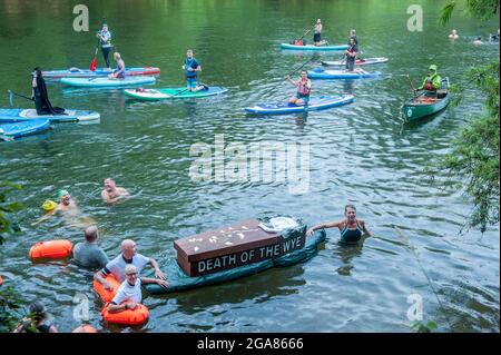 Die Spezialistin für Wildschwimmen und Autorin Angela Jones alias „The Wild Woman of the Wye“ führt ein 1-km-Bad im Monmouth-Abschnitt des Wye-Flusses, um auf den katastrophalen ökologischen Zustand des Flusses Wye und seine anhaltende Verschlechterung aufmerksam zu machen. Ein Nachbau-Sarg auf einem Paddelbrett wurde in den Fluss gesenkt und von Angela geschleppt, um den Tod des Wye darzustellen. Ihr Schwimmen ist Teil der #SaveTheWye, einer Dachkampagne zur Unterstützung und zum Aufbau eines Netzwerks von Organisationen und Einzelpersonen, die sich für den Schutz und die Wiederherstellung der Gesundheit des Flusses Wye und seiner Nebenflüsse einsetzen, sowohl für die Tierwelt als auch für die Menschen Stockfoto