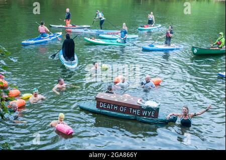 Die Spezialistin für Wildschwimmen und Autorin Angela Jones alias „The Wild Woman of the Wye“ führt ein 1-km-Bad im Monmouth-Abschnitt des Wye-Flusses, um auf den katastrophalen ökologischen Zustand des Flusses Wye und seine anhaltende Verschlechterung aufmerksam zu machen. Ein Nachbau-Sarg auf einem Paddelbrett wurde in den Fluss gesenkt und von Angela geschleppt, um den Tod des Wye darzustellen. Ihr Schwimmen ist Teil der #SaveTheWye, einer Dachkampagne zur Unterstützung und zum Aufbau eines Netzwerks von Organisationen und Einzelpersonen, die sich für den Schutz und die Wiederherstellung der Gesundheit des Flusses Wye und seiner Nebenflüsse einsetzen, sowohl für die Tierwelt als auch für die Menschen Stockfoto