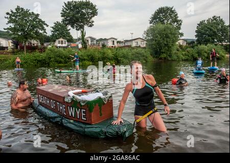 Die Spezialistin für Wildschwimmen und Autorin Angela Jones alias „The Wild Woman of the Wye“ führt ein 1-km-Bad im Monmouth-Abschnitt des Wye-Flusses, um auf den katastrophalen ökologischen Zustand des Flusses Wye und seine anhaltende Verschlechterung aufmerksam zu machen. Ein Nachbau-Sarg auf einem Paddelbrett wurde in den Fluss gesenkt und von Angela geschleppt, um den Tod des Wye darzustellen. Ihr Schwimmen ist Teil der #SaveTheWye, einer Dachkampagne zur Unterstützung und zum Aufbau eines Netzwerks von Organisationen und Einzelpersonen, die sich für den Schutz und die Wiederherstellung der Gesundheit des Flusses Wye und seiner Nebenflüsse einsetzen, sowohl für die Tierwelt als auch für die Menschen Stockfoto