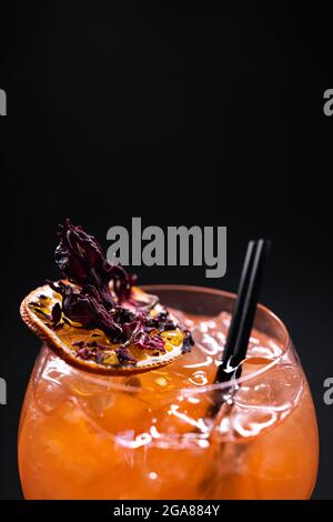 Nahaufnahme eines orangefarbenen aperol Spritz-Litschi-Cocktails in Glas auf schwarzem Hintergrund Stockfoto