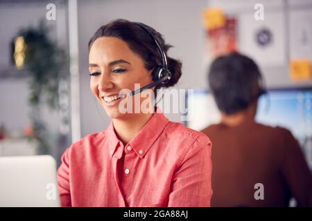 Geschäftsteam Mit Telefon-Headsets Im Gespräch Mit Anrufern In Der Kundendienstabteilung Stockfoto