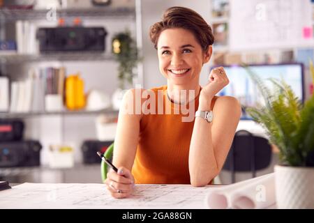 Porträt Einer Architektin Im Büro, Die Am Schreibtisch Arbeitet Und Notizen Zu Plan Oder Blueprint Macht Stockfoto