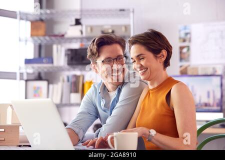 Männliche Und Weibliche Architekten Im Büro Arbeiten Am Schreibtisch Auf Laptop Zusammen Mit Heißen Getränken Stockfoto