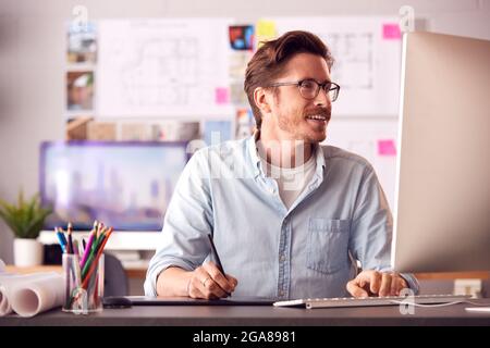 Männlicher Architekt Im Büro, Der Auf Einem Desktop-Computer Mit Einem Grafiktablett Arbeitet Stockfoto