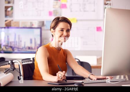 Weibliche Architektin Im Büro, Die Am Desktop-Computer Mit Einem Grafiktablett Arbeitet Stockfoto