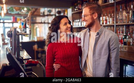 Porträt Eines Lächelnden Paares Mit Bar, Das Hinter Dem Counter Steht Stockfoto