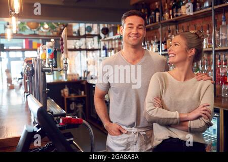 Porträt Eines Lächelnden Paares Mit Bar, Das Hinter Dem Counter Steht Stockfoto