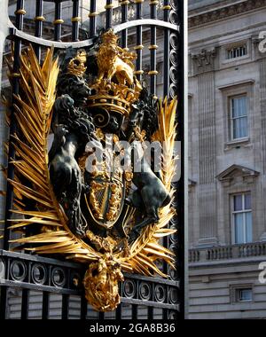 Die Sonne scheint auf dem königlichen Wappen des Vereinigten Königreichs am offenen Tor des Buckingham Palace Stockfoto