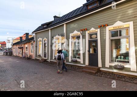 Porvoo, Finnland - 7. Mai 2016: Touristen spazieren auf der Straße der alten Stadt Porvoo in der Nähe von Souvenirläden Stockfoto